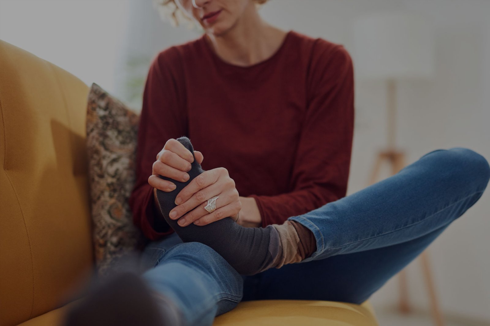 Diabetic Neuropathy study FSTrials in Austin, Texas. Woman massaging feet on couch.